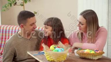 <strong>爸爸妈妈</strong>看着女儿，然后同时在镜头中展示复活节彩蛋。 在前景是