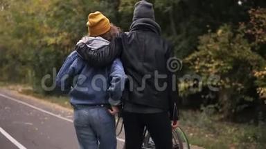 秋天<strong>公园</strong>的城市<strong>公园里</strong>，一对可爱的年轻夫妇抱着自行车开始<strong>散步</strong>。积极生活方式的概念