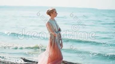孤独的旅人，穿着一件粉红色的长裙子，站在<strong>蔚蓝</strong>的<strong>大海</strong>的岸边，想着，拥抱着自己