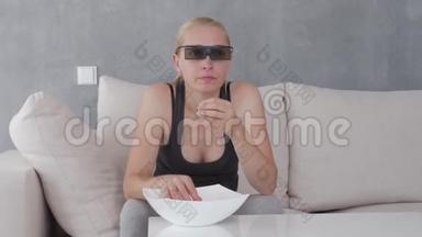 一个女人在柔软的沙发上吃爆米花，看着3D眼镜里的<strong>电视屏幕</strong>。