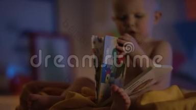 可爱的宝宝只是坐在不好的地方玩一本书，并展示如何阅读与专注的书