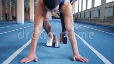 带假肢的短跑运动员站在<strong>起跑线</strong>上，近距离。