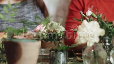 桌子上摆着许多有花的小盆子，两个女孩围坐在一起，和花匠一起工作
