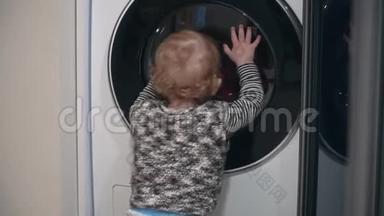 一岁男孩在家看<strong>洗衣机</strong>。 小男孩关上<strong>洗衣机</strong>