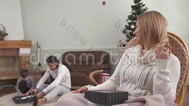 <strong>幸福</strong>的女人坐在摇椅上看着父亲和小儿子玩无人机。 家庭<strong>幸福</strong>。