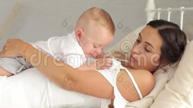 年轻的<strong>母亲抱</strong>着她新生的<strong>孩子</strong>。 女人和新出生的男孩放松。
