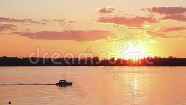 令人惊叹的湖泊景观，海岸线，漂浮的船只在美丽的橙色日落。
