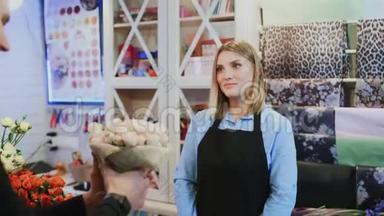 女孩花店正在卖花束给商店的男花店老板
