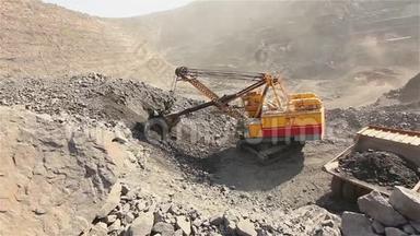 挖土机和翻斗车在采石场，大型黄色挖掘机将矿石装入翻斗车，工业外部