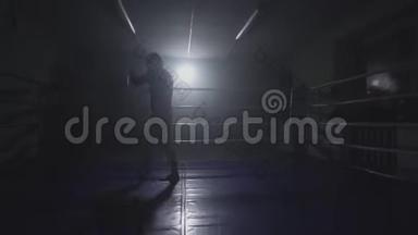 低光环中的跆拳道训练。 在烟雾弥漫的健身房里打拳击
