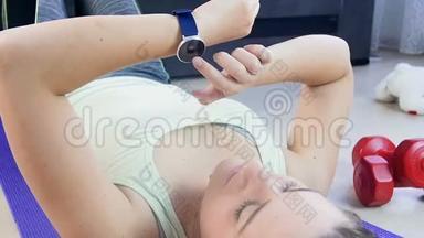 年轻女子在做运动前手腕上使用健身追踪器的慢动作镜头