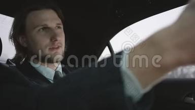 漂亮的男人，棕色头发，穿着开心果衬衫，穿着灰色西装，坐在车里，付钱兜风