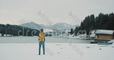 译文：年轻的游客欣赏着冬天中带着白雪森林的湖光山色，他是
