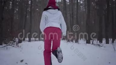 非裔美国女孩穿过冬季森林。 穿暖和夹克的漂亮女孩转过身来，环顾四周，她吓坏了