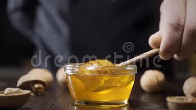 厨师蘸木蜂蜜，用液体蜂蜜粘在玻璃碗上，用蜂蜜烹饪，用天然蜂蜜做甜食