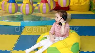 小女孩在用手机说话。 婴儿<strong>手中</strong>的新数字技术。 有智能手机的小孩画像