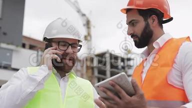 幸福工程师在施工现场用手机讲话，检查工人工作情况.. 建筑商会谈