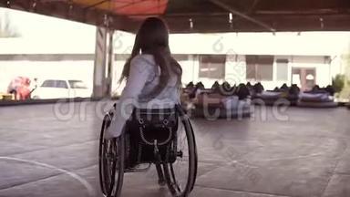 残疾残疾的残疾青年妇女坐轮椅在电动汽车的吸引面上跳舞
