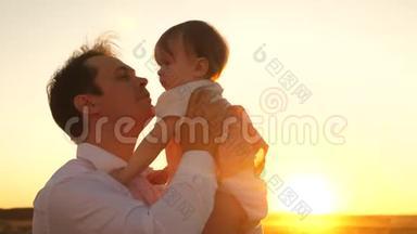 快乐的爸爸在公园里亲吻小女儿。 快乐童年的概念。 父亲带着小孩在阳光下玩耍