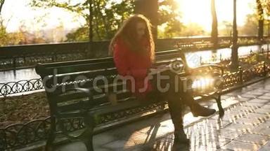 秋天阳光明媚的一天下午在公园里，<strong>小姐</strong>正在看书，女孩正拿着书包坐在公园的长椅上，秋天
