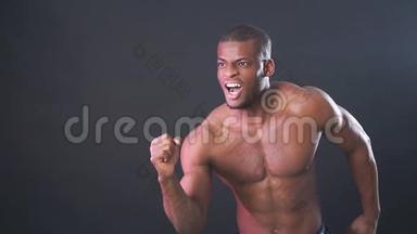 肌肉男非洲健美运动员。 男人在黑色背景上摆姿势，展示他的健康和完美的形状。