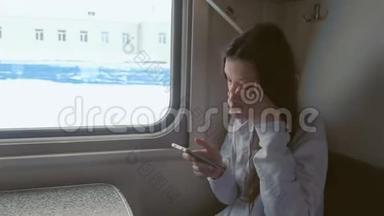 疲惫的年轻女子在移动列车上在线登记在手机上。