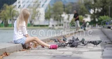 夏天，一个漂亮的孩子在湖边<strong>喂鸽子</strong>面包。
