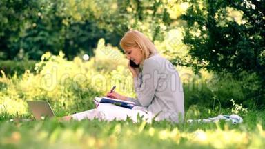 年轻的女学生坐在公园里学习。 美丽的花园。 <strong>春夏</strong>休闲活动..