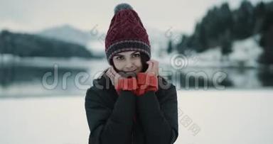 一位年轻女士在一个大湖和雪山旁边的特写肖像，直视着摄像机，摆着姿势，展示了一个