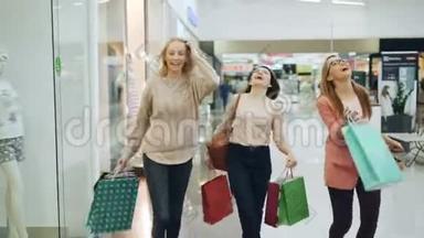 一群快乐的女孩在购物中<strong>心</strong>玩得很开<strong>心</strong>，他们拿着纸袋<strong>走</strong>路，笑着跳舞，指着里面的商品