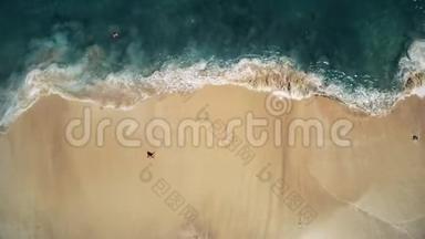 人站在黄沙滩上，在波涛汹涌的海浪中