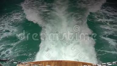 完美游艇绿松石水域甲板背面明亮的近景，在螺旋流中变成白色