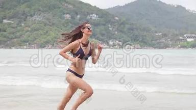 穿着比基尼的年轻漂亮开朗的女人在自由的乐趣中奔跑。