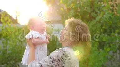 快乐的母亲和宝贝<strong>女孩</strong>。 带着笑<strong>脸</strong>的婴儿<strong>正</strong>在妈妈`手上挥手。 镜头反射。