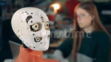 特写一个机器人的面部表情和一位女士在后台工作