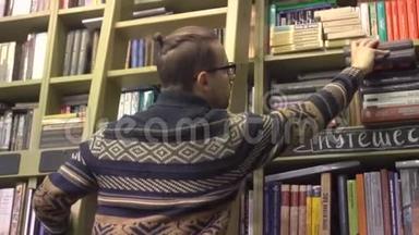 图书馆里的一个年轻人爬上楼梯，在书架上找一本书