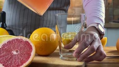 女人正在把柑橘汁从<strong>榨汁机</strong>倒入玻璃杯