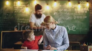 <strong>老</strong>师和小男孩在绿板和胡子<strong>教授</strong>的背景上画画和交谈。 回到学校背景