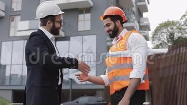 施工经理和工人在施工现场握手.. 专业、建筑、工人、建筑师