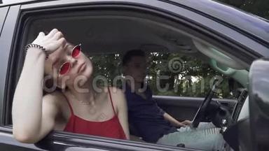 一对年轻夫妇坐着一位身穿红衫、戴着太阳镜的女士开车旅行，她的男朋友正在开车