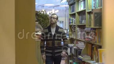一个人走在书架之间。 这是书店或图书馆。
