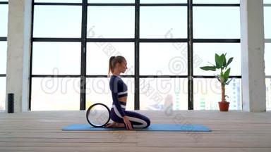 室内瑜伽。 体育娱乐。 美丽的年轻女子在阿萨纳与瑜伽戒指初学者。 个人运动。 会议室