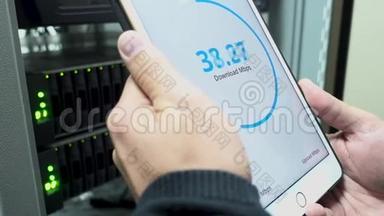 信息技术工程师测量网络速度。 手里拿着一台平板电脑。 LED指示的背景。 的背景