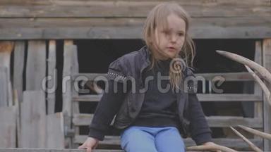 漂亮时尚的小村庄女孩坐在木制建筑上