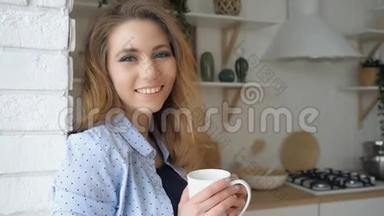 头发松松的女孩喝茶，微笑着靠在砖墙上