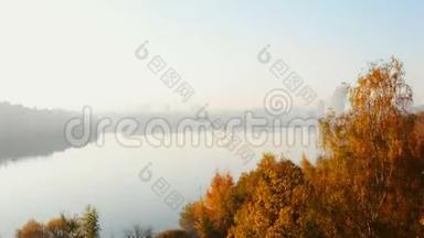 在<strong>黄</strong>色的秋树之上升起的无人机，揭示了<strong>大气</strong>的城市天际线和平静的湖面，笼罩着晨雾。