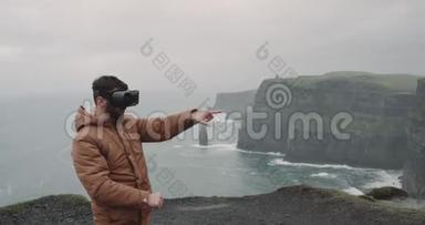 一位年轻的游客在悬崖顶的VR时间，他用VR探索这个地方，感觉印象深刻，站在上面。
