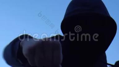不明身份的暴徒用拳头打摄像机，危险的罪犯影子拳击