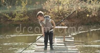 小有趣的男孩教如何在湖上捕鱼，他拿着一根大鱼竿。