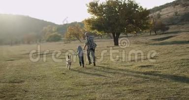 令人惊叹的家庭日爸爸和他的儿子<strong>一起跑</strong>在他们的哈士奇狗旁边的自然，美丽惊人的景色。